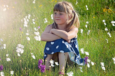 girl in blue and white dress sitting on grass thumbnail