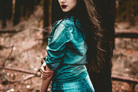 woman holding right elbow standing beside tall tree thumbnail