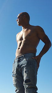 man wearing distressed blue denim jeans thumbnail