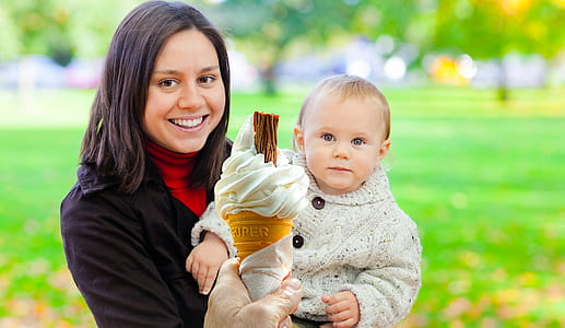 Photo illustration of woman holding a child while being offered an ice cream cone. thumbnail