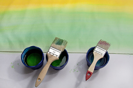 two brown paint brush on blue plastic cups thumbnail