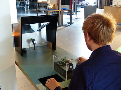 person wearing blue dress shirt standing near 3D printer thumbnail