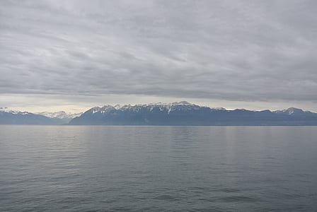 calm water front of mountain at daytime thumbnail
