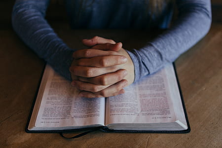 opened bible book on top of brown surface thumbnail