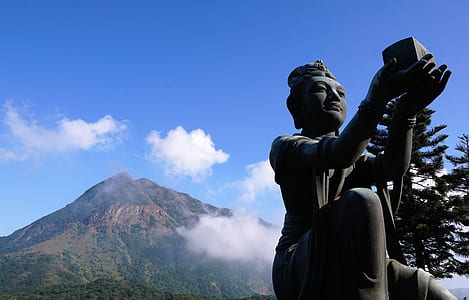 low-angle photography of Hindu deity statue with mountain background thumbnail