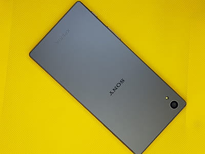 gray Sony Xperia smartphone on yellow surface thumbnail