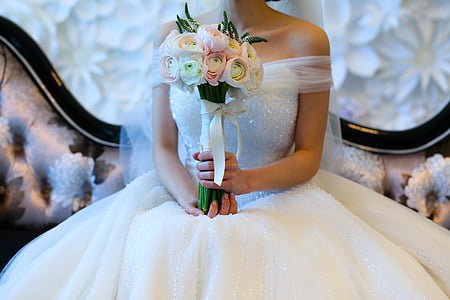 bride holding white and pink bouquet of flowers thumbnail