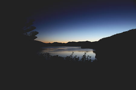 silhouette of mountains and body of water thumbnail
