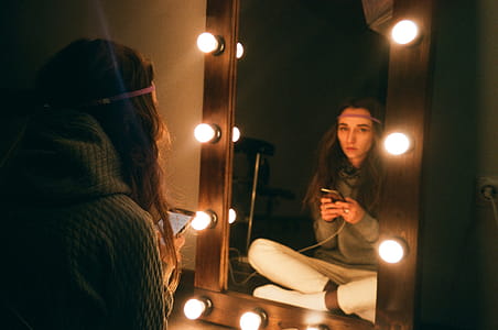 Woman Sitting in Front of Vanity Mirror thumbnail