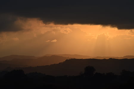 silhouette of mountains under cloudy sky thumbnail