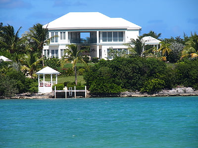 white house near shore beside body of water thumbnail