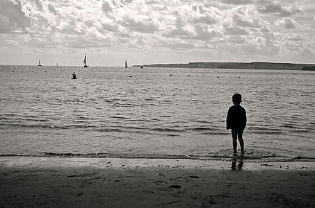silhouette photography of boy on seashore thumbnail
