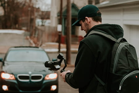 man standing while holding camera stabilizer thumbnail