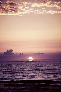 calm sea under beige sky during sunset thumbnail