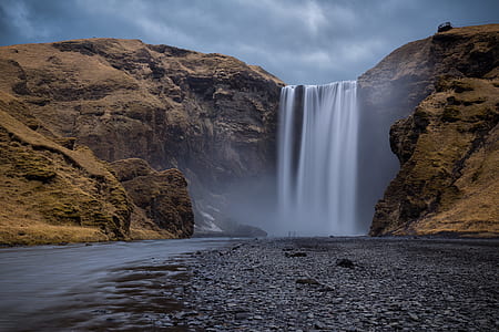 waterfall pouring in a brown land formation thumbnail
