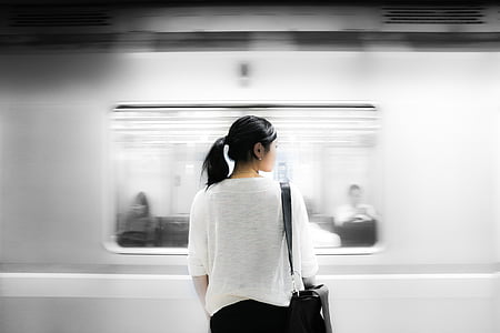 woman standing beside running train thumbnail