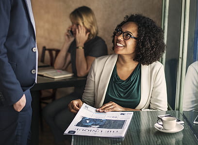 Smiling Woman Sitting on Chair Beside Table and Window thumbnail