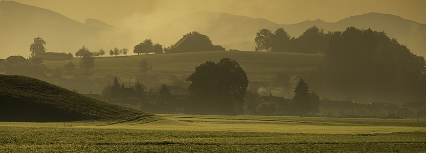 green grass field near trees and mountains thumbnail