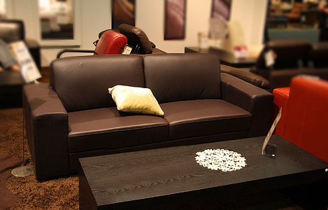 brown leather sofa with pillow near coffee table thumbnail