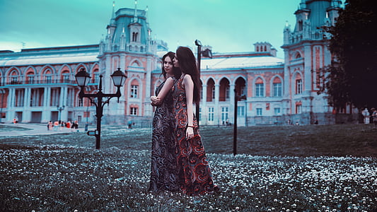 photo of two woman wearing dress standing near on post lamp thumbnail