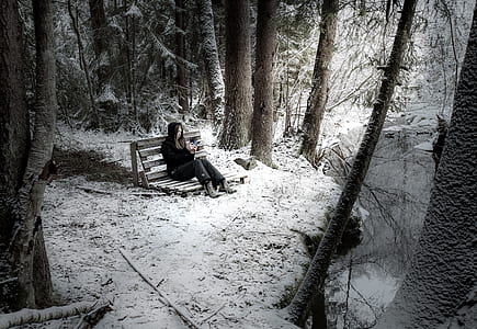 woman sitting on bench beside river thumbnail