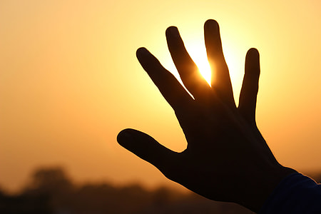 Man’s hand extended at sunset thumbnail