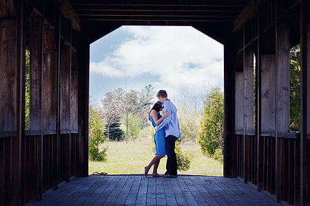 man in blue long-sleeved shirt embracing woman in blue dress thumbnail