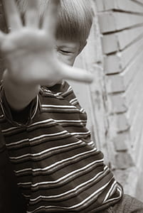 boy covering his face with hand in grayscale photography thumbnail