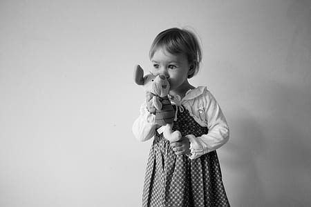 grayscale photo of girl holding Winnie The Pooh Piglet plush toy thumbnail