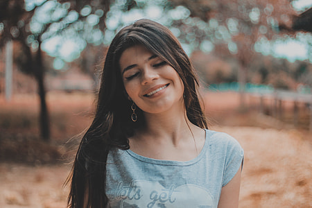 woman wearing gray shirt standing in front of trees thumbnail