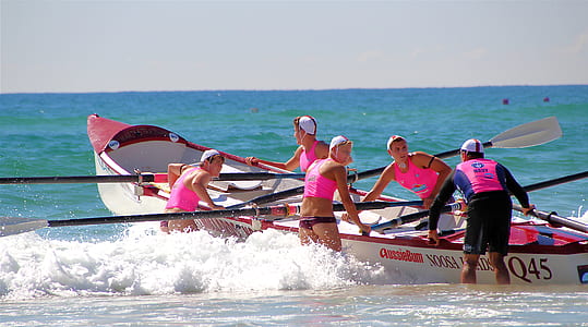 group of people holding boat in body of water thumbnail
