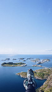 person showing shoes overlooking blue sea thumbnail