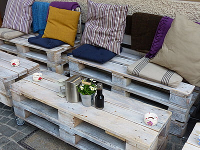 gray wooden pallet themed bench with pads beside table thumbnail
