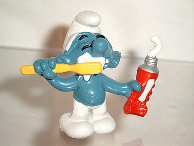 smurf holding toothbrush and toothpaste figurine thumbnail
