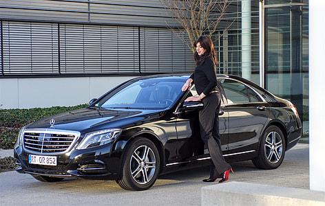 woman near black Mercedes-Benz sedan near building thumbnail