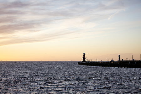 in distant photo of lighthouse during golden hour thumbnail