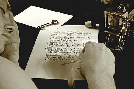 man writing on white lined paper thumbnail