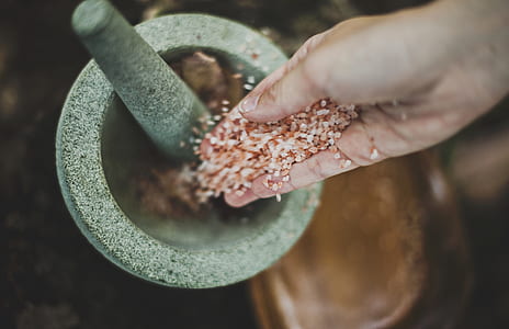 person pouring herbs on mortar thumbnail