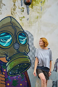 woman standing beside gas mask graffiti thumbnail