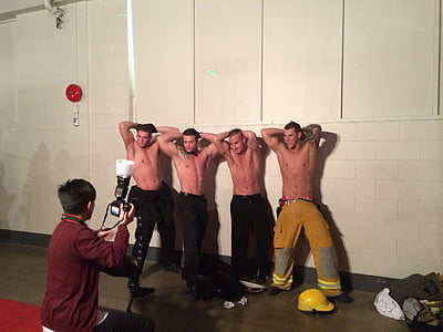 four men standing beside white painted wall thumbnail