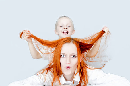 closeup photo of a woman with a boy in her back holding her hair thumbnail