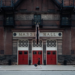 woman walking near white-and-red wooden doors thumbnail