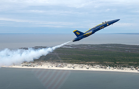 blue and yellow jet in flight with white smoke during daytime thumbnail