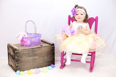 girl doll sitting on pink rocking armchair beside the brown wooden box thumbnail