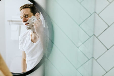 man shaving beard in front of mirror thumbnail