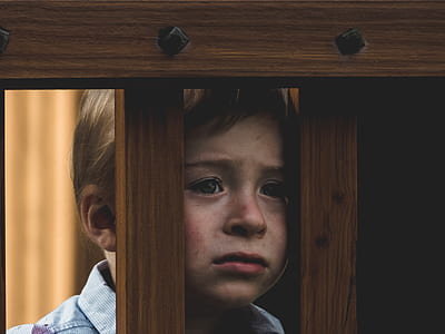 boy in front of brown wooden frame thumbnail