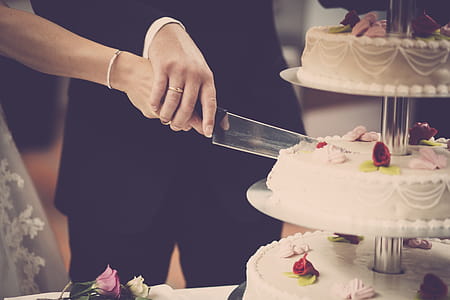 Person Holding Knife Slicing 3-layer Cake thumbnail