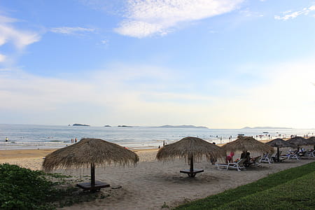Traditional thatched sun shade umbrellas on a tropical beach thumbnail
