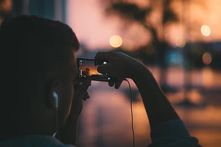 person taking photo of sunset thumbnail
