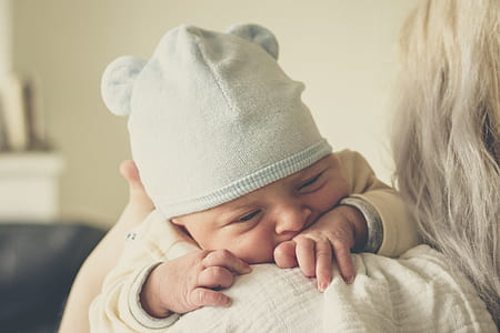 person carrying baby with blue beanie thumbnail
